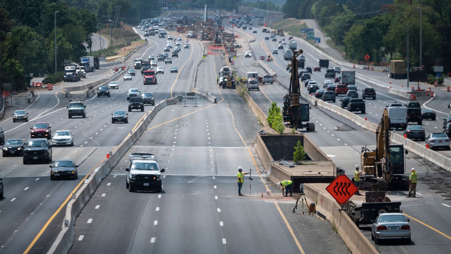 Cars drive past construction workers along Interstate Highway 66 in Manassas, Virginia, on August 10, 2021. Andrew Caballero-Reynolds/AFP/Getty Images